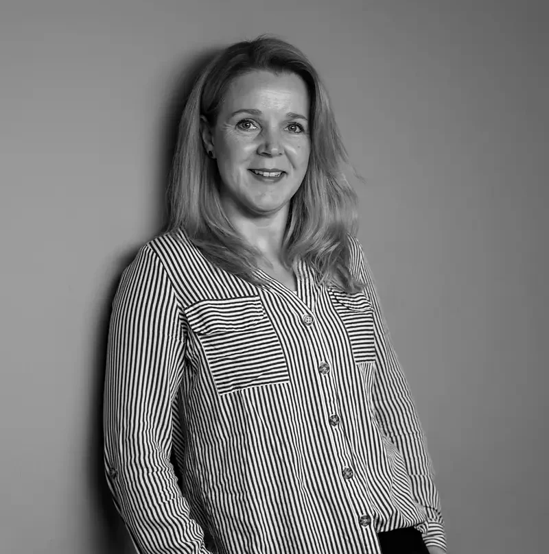 Eine Frau mit langen Haaren lächelt und trägt ein gestreiftes Hemd.